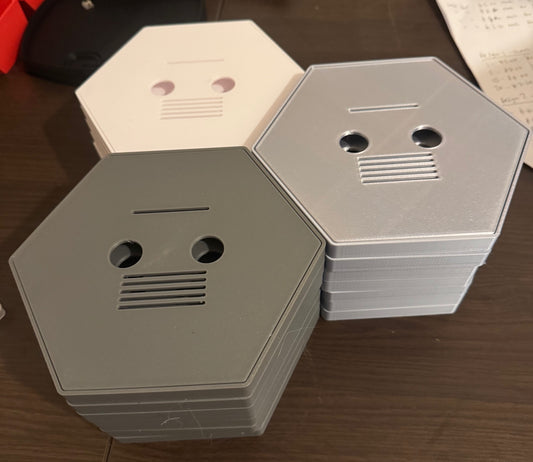 Hexagonal metal boxes stacked on a wooden surface